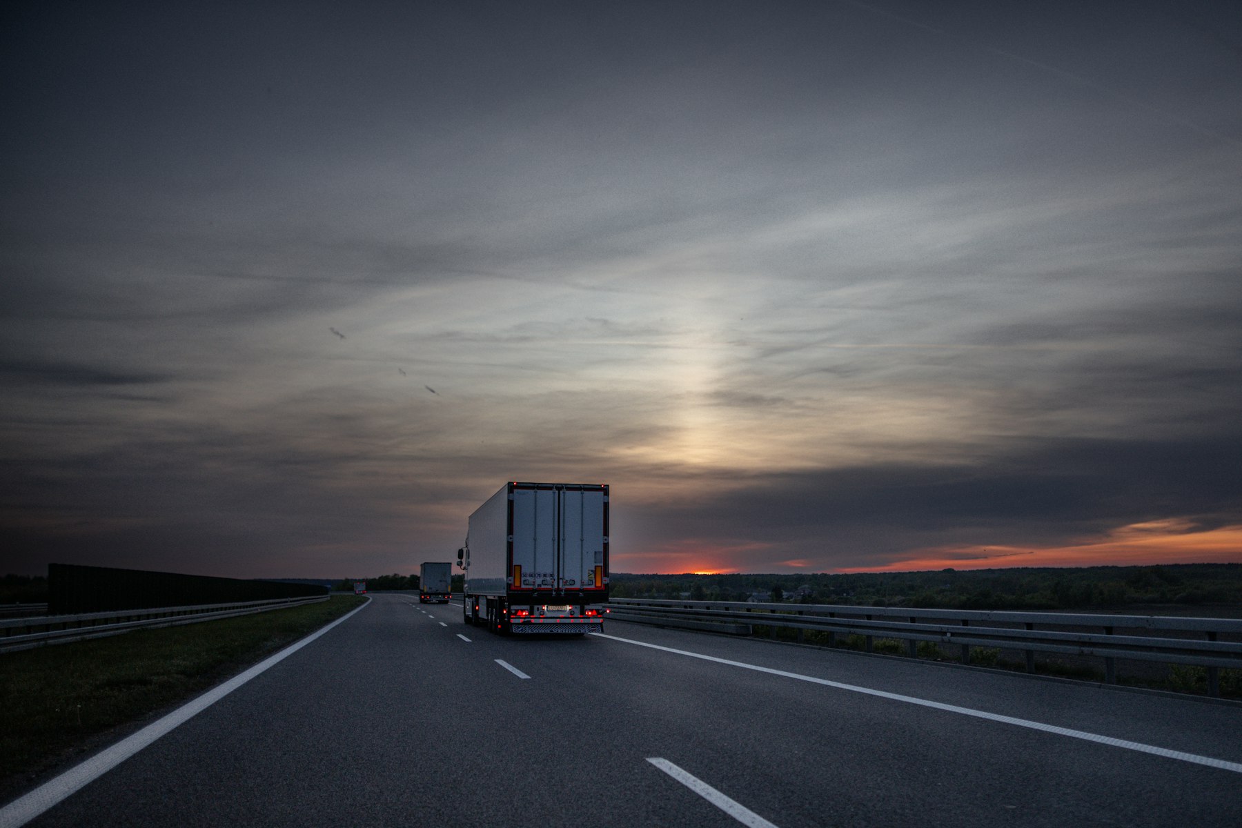 Dry van truck on a dark highway at dusk